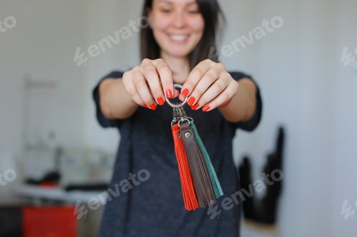 Preview: Smiling Female Person Standing With Leather Handmade Trinkets At Home Atelier. Concept Of