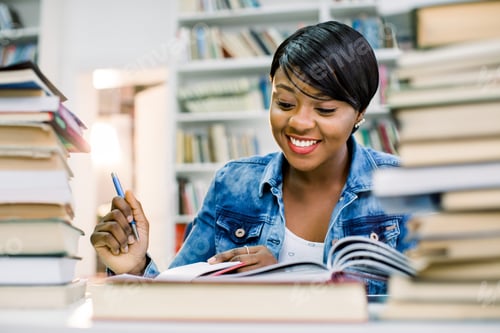 Preview: Pretty Teenage Black African College Student Girl Studying And Reading A Book In College Library