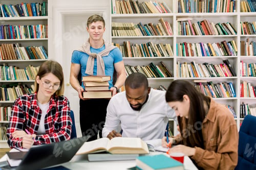 Preview: Multiethnic Group Of Young People, Students, Studying Together At The Table, Reading Books. Young
