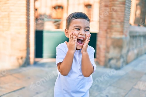 Preview: Adorable Hispanic Boy With Hands On Face Smiling Happy At The City.