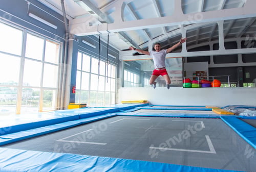 Preview: Fitness, Fun, Leisure And Sport Activity Concept - Handsome Happy Man Jumping On A Trampoline