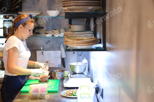 Preview: Girl Female Woman Chef Prepares Dishes In The Restaurant, Pours Into A Bowl, Gloved Hands, A