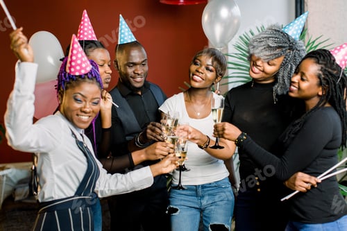 Visualização: Grupo de amigos africanos felizes bebendo champanhe e comemorando a festa de aniversário