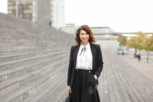 Preview: European Businesslady Standing On Stairs Outside In High Buildings Background. Concept Of