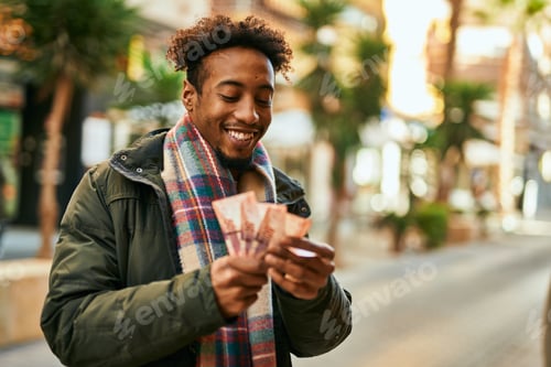 Preview: Young African American Man Smiling Happy Holding South Africa Rands Banknotes At The City