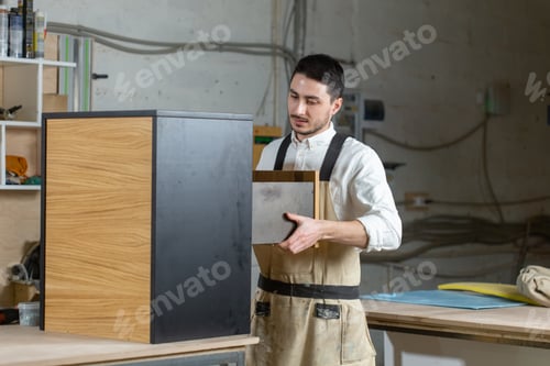 Preview: Furniture Factory And Small And Medium Sized Enterprises Concept - Man Collects Furniture Details
