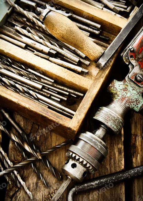 Preview: The Old Working Tool. An Old Drill, A Box With Drills On A Wooden Background.