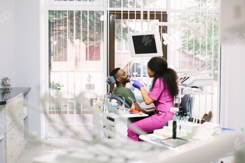 Preview: Medicine, Dentistry And Healthcare Concept - Dentist With Tooth Color Samples Choosing Shade For