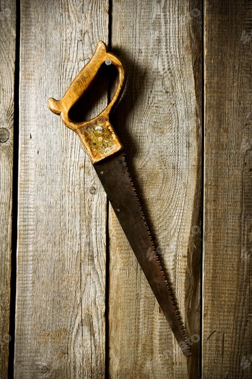 Preview: The Saw Hangs On A Nail. On A Wooden Background.