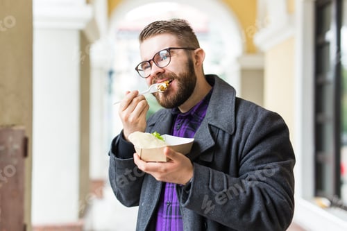 Preview: Fast Food And Meal Concept - Young Man Eating Take Away Food On The Street