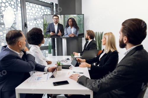 Preview: Focused Multiracial Business People In Conference Room, Looking At A Screen, Having Video