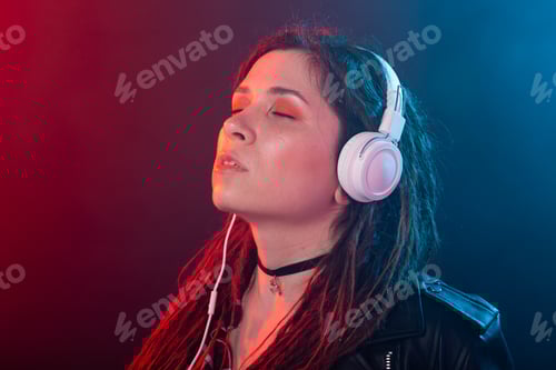 Visualização: Jovem mulher com dreadlocks aprecia a música em seus fones de ouvido