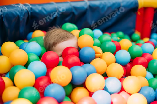 Vista previa: Happy Laughing Boy 1-2 Years Old Having Fun In Ball Pit On Birthday Party In Kids Amusement Park