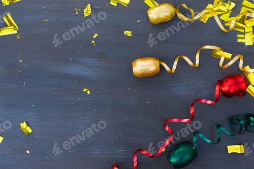 Preview: Carnaval Festive Curling Paper And Confetti With Copy Space On Dark Wooden Background