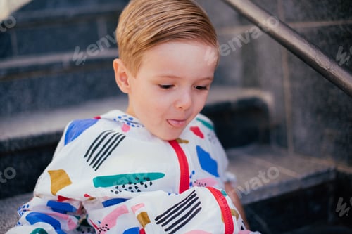 Preview: A Young Cute Happy 4 Years Old Boy Posing And Playing Outside, Wearing Colorfull Jacket