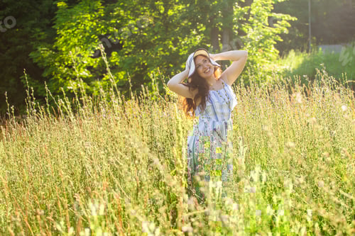 Preview: Happy Young Woman With Long Hair In Hat And Dress Walking Through The Summer Forest On A Sunny Day
