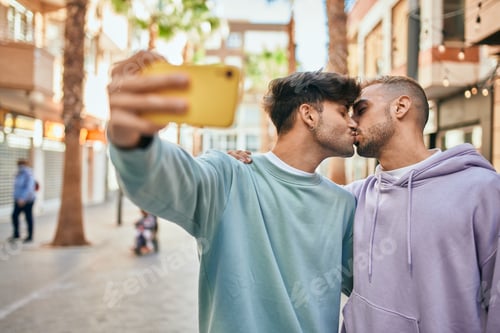 Preview: Young Gay Couple Kissing And Making Selfie By The Smartphone At The City.