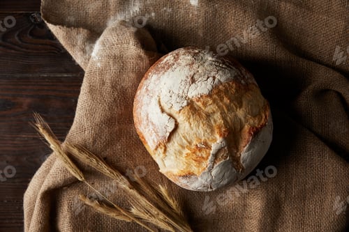 Preview: top view of bread, wheat, sackcloth covering by flour on wooden table