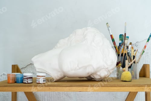 Preview: An Artistic Workspace that showcases a Bust along with a range of Painting Supplies for creative