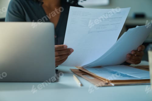 Preview: African american woman sitting at the table and studying documents