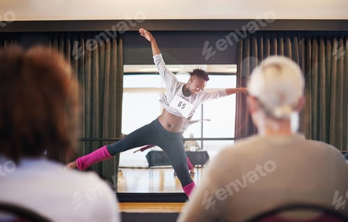 Preview: Moving to the music. Shot of a female dancer performing before the judges during a dance audition.