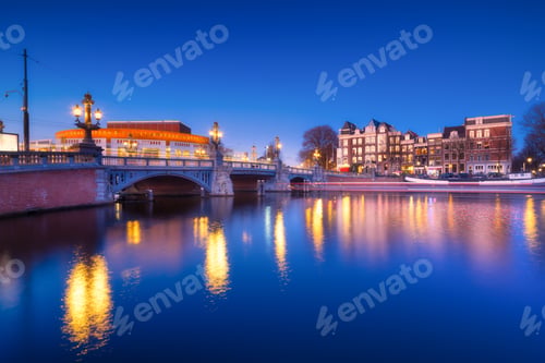 Preview: Blue bridge, Amsterdam, Netherlands. Blauwbrug. Evening cityscape. Blue sky and city lights.