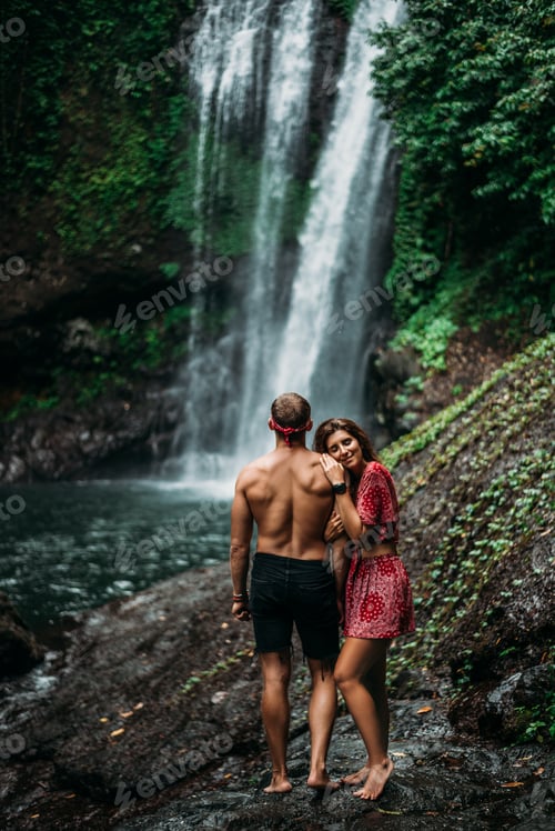 Preview: A beautiful girl embraces a man of athletic build at the waterfall. Happy couple in Bali