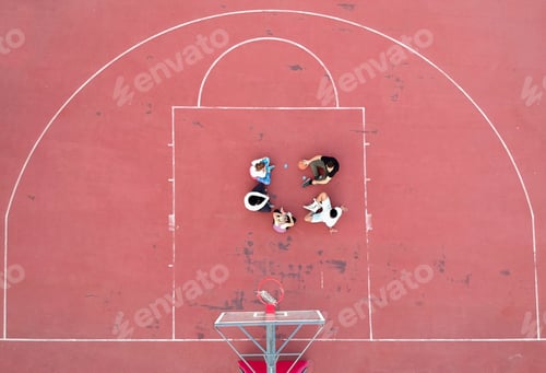 Preview: Above view of determined basketball playersstanding on court at daytime