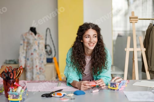Preview: Smiling fashion designer joyfully looking aside working with tex