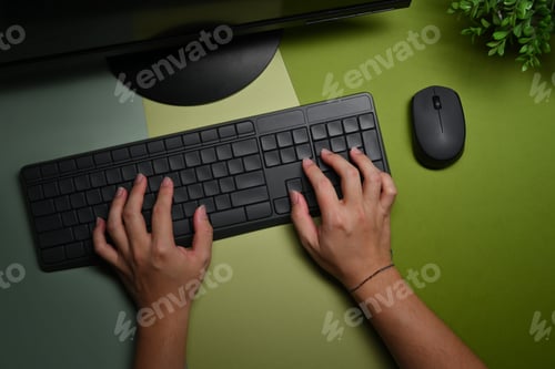 Preview: Overhead view young man hands typing on wireless keyboard.