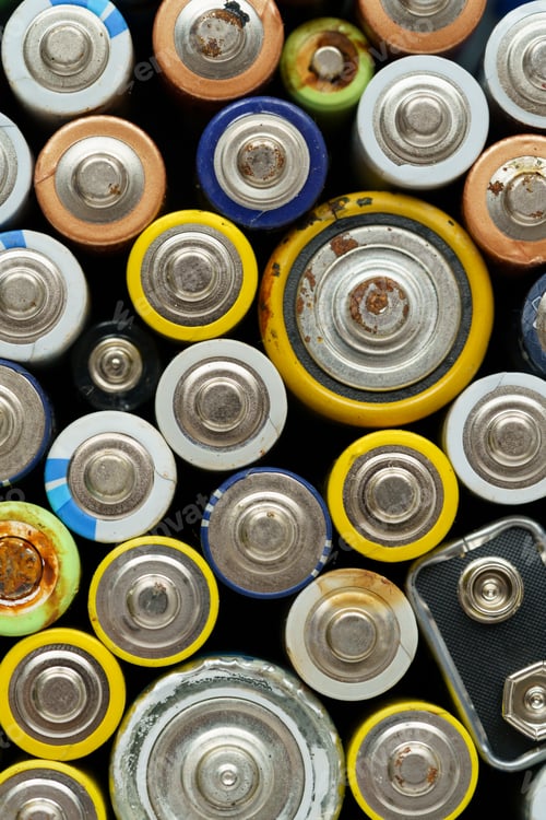 Preview: Close up top view of used battery. Electronic hazardous waste concept. Batteries background