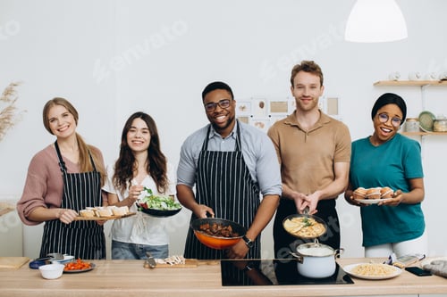 Preview: Diverse friends enjoying cooking dinner together in kitchen