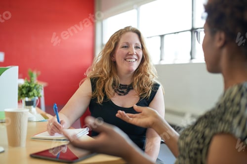 Preview: Unposed group of creative business people in an open concept office brainstorming.