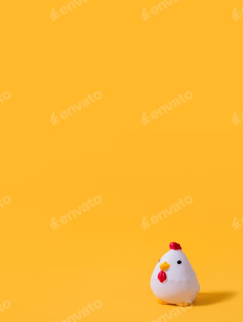 Preview: Rubber toy rooster on a yellow background. Children's background. Children's toy. Copy space