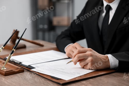 Preview: Notary signing document at wooden table in office, closeup