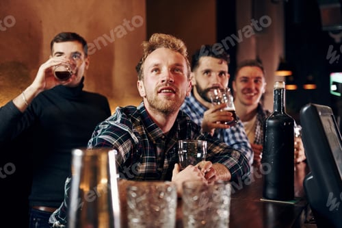 Preview: Group of people together indoors in the pub have fun at weekend time