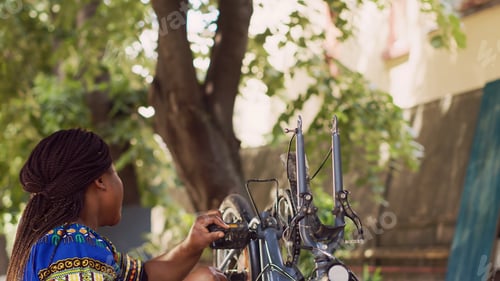 Preview: Energetic woman grabbing bicycle wheel