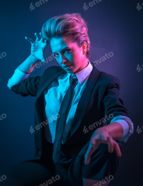 Preview: A sexy young blonde hair female in a black suit posing in studio