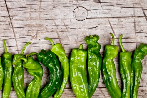 Preview: Fresh green raw peppers on rustic wooden table background.