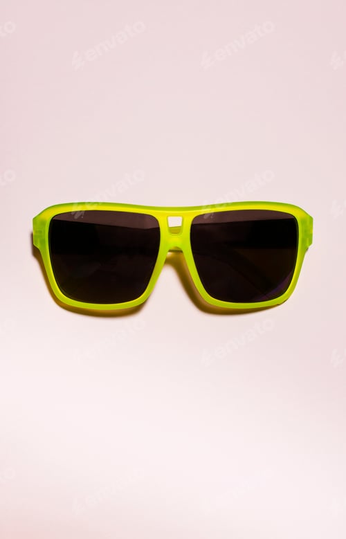 Preview: Green bright sunglasses on a pastel pink background. Summer time, party and vacations concept.