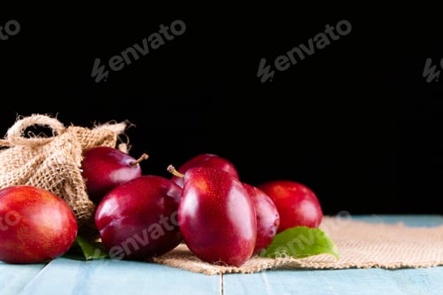 Preview: Fresh Plums in Burlap Sack on Blue Table