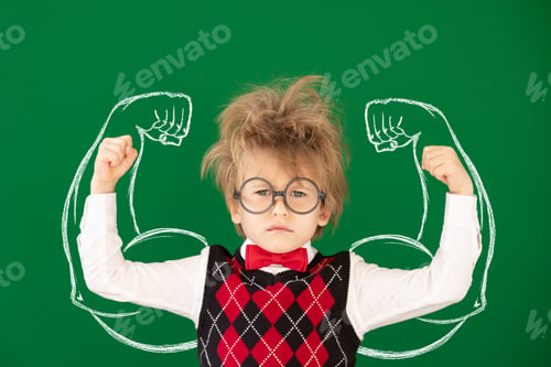 Preview: Happy child in class against green chalkboard