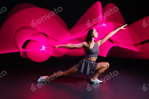 Preview: young girl sportswoman doing sports in neon light, concept modern sports training,