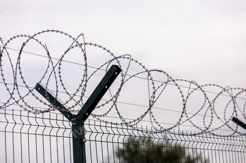 Preview: fence of barbed metal wire against the background of clouds, the concept of freedom, unfreedom