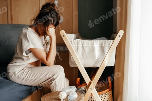Preview: Mental health. Breastfeeding problems. Depressed mom pumping breast milk while newborn son sleeping