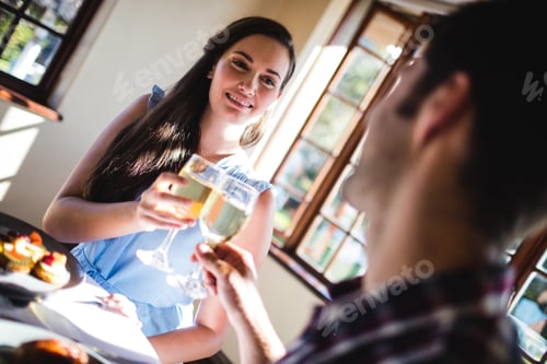 Preview: Couple toasting white wine glass in restaurant