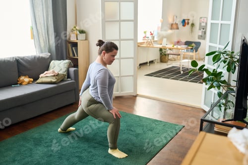 Preview: Girl with mental disability doing stretching exercise on the floor at home