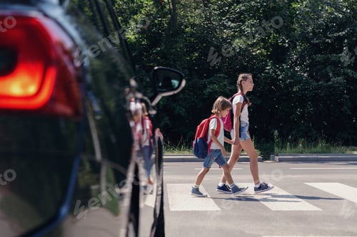 Preview: Children next to a car walking through pedestrian crossing to the school