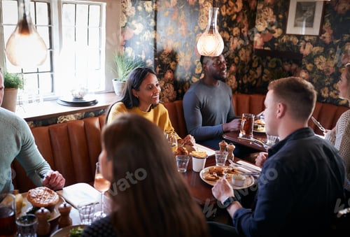 Preview: Group Of People Eating In Restaurant Of Busy Traditional English Pub