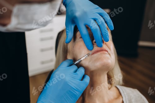 Preview: Botox, injection and antiaging with a senior woman in studio on a gray background with hands